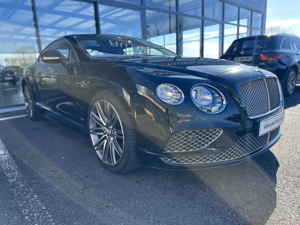 Bentley Continental GT Speed noire vue en 3/4 avant droit, mettant en valeur sa calandre et ses phares ronds distinctifs.