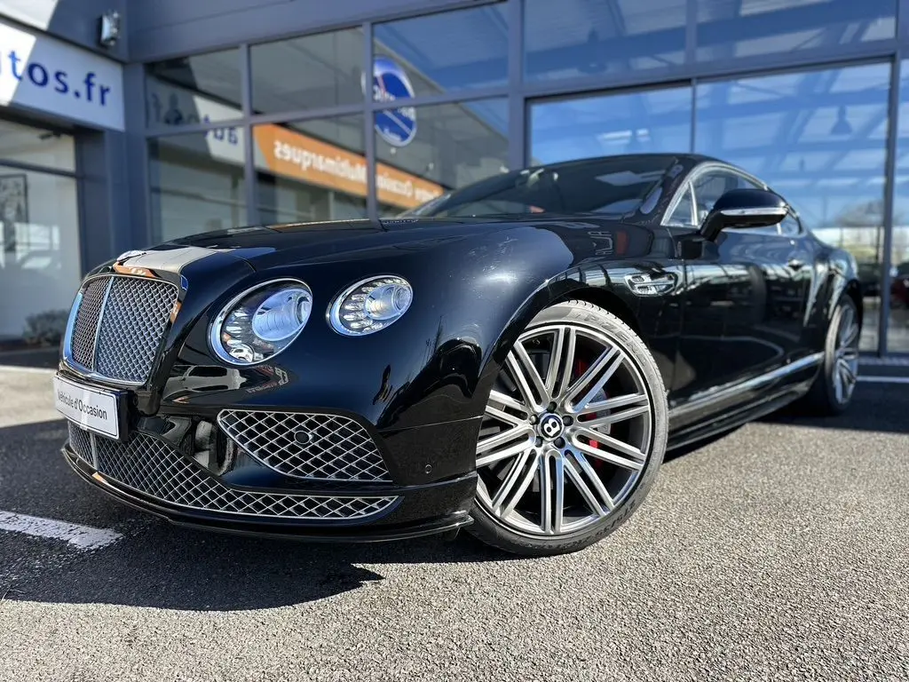 Bentley Continental GT Speed noire vue 3/4 avant droit, avec calandre chromée et jantes alliage distinctives.