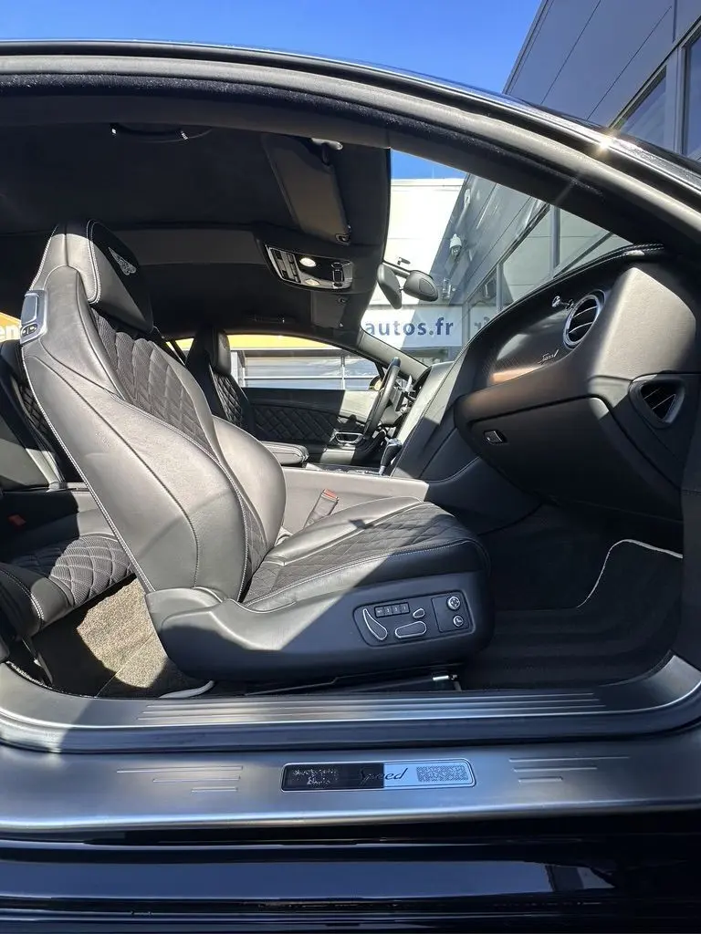 Intérieur noir de la Bentley Continental GT Speed 2015 vu côté gauche, siège cuir avec surpiqûres et logo Bentley brodé.
