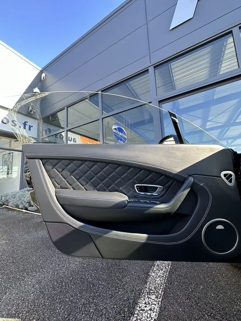 Porte côté gauche de la Bentley Continental GT Speed 2015 noire, cuir matelassé et finitions élégantes visibles.