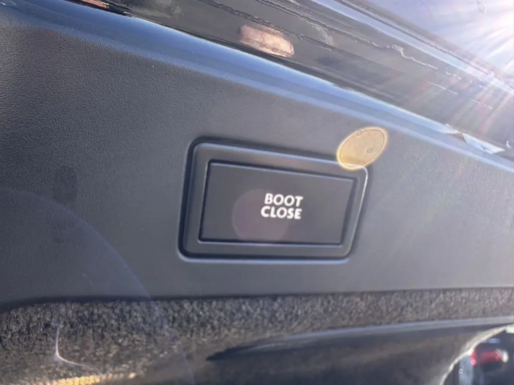 Bouton "Boot Close" en gros plan sur la garniture intérieure du coffre d'une Bentley Continental GT noire 2015.