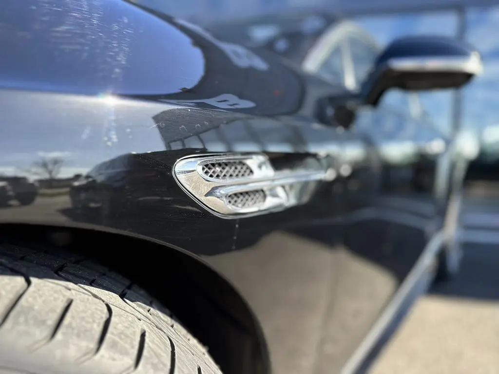 Détail de la prise d'air chromée sur l'aile avant gauche d'une Bentley Continental GT Speed noire 2015.