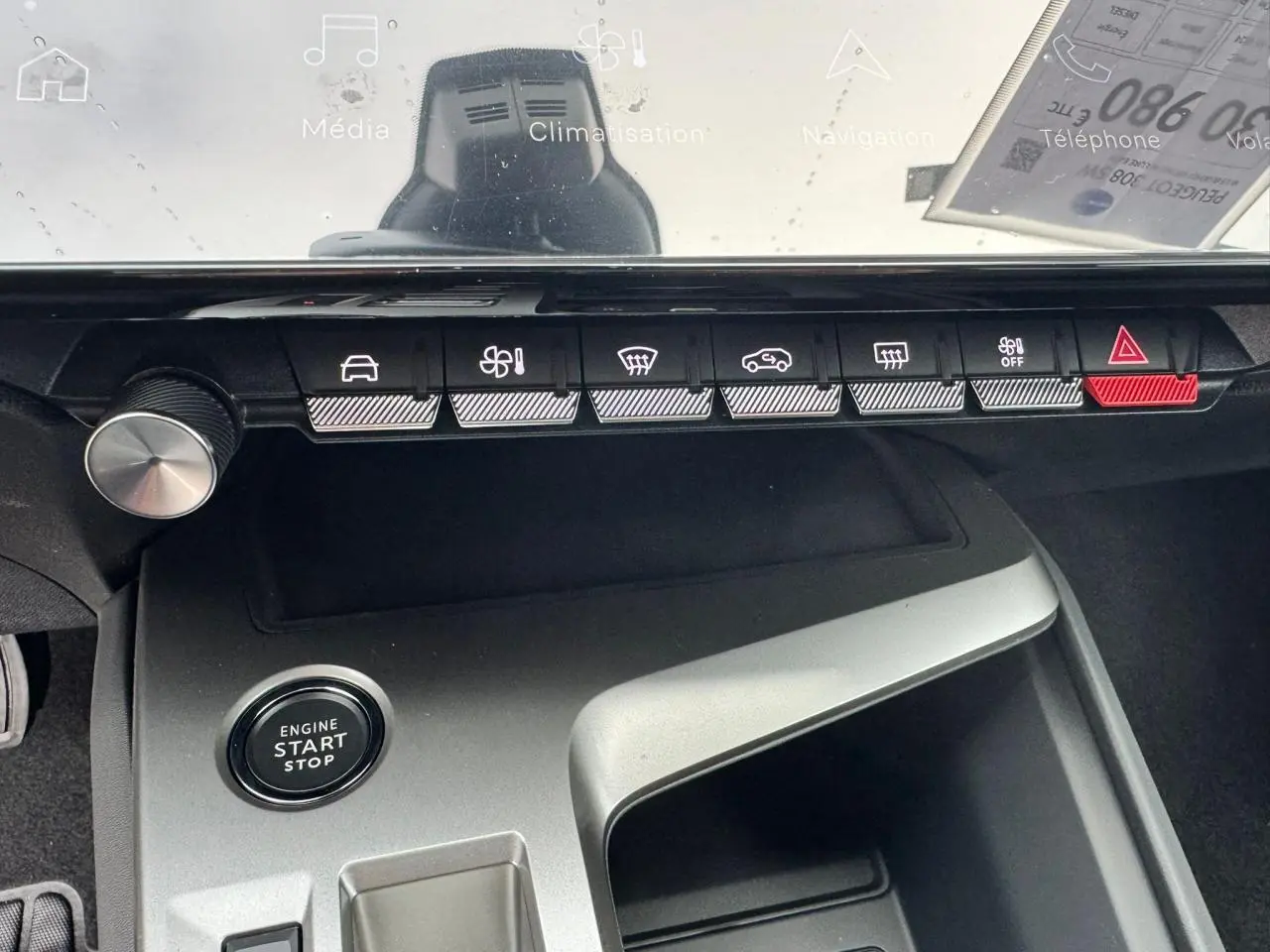 Vue rapprochée de la console centrale de la Peugeot 308 SW blanche, avec boutons de commande et bouton start/stop.