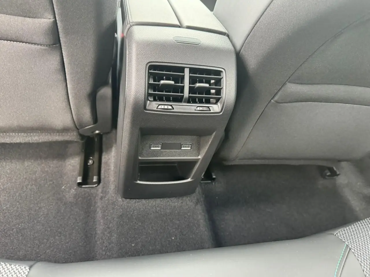 Vue rapprochée de la console centrale arrière noire avec bouches d'aération et prises USB-C du Peugeot 308 SW blanc Okenite.