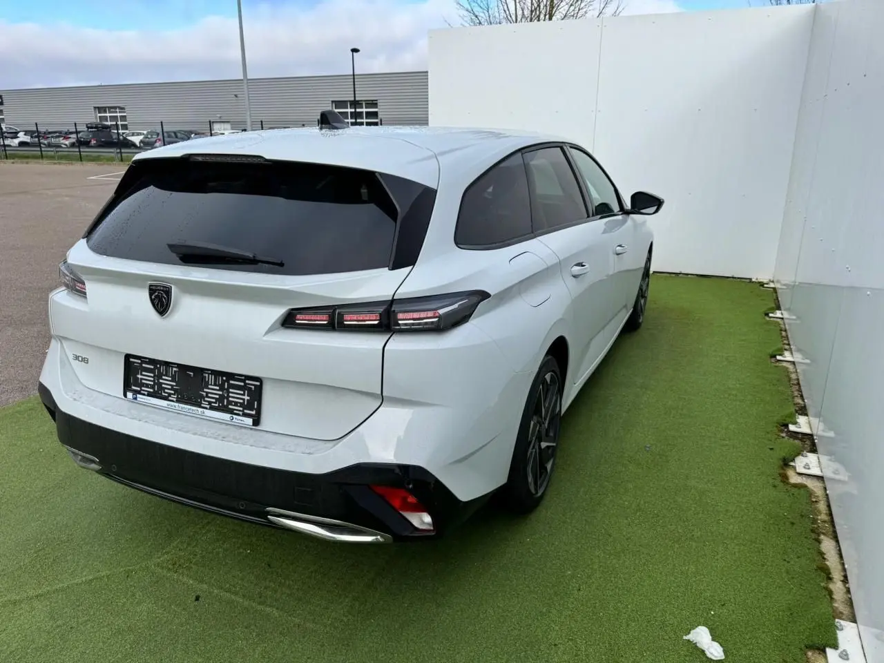 Peugeot 308 SW blanc Okenite vue 3/4 arrière droit, feux LED et jantes alliage 17'' Halong diamantées visibles.