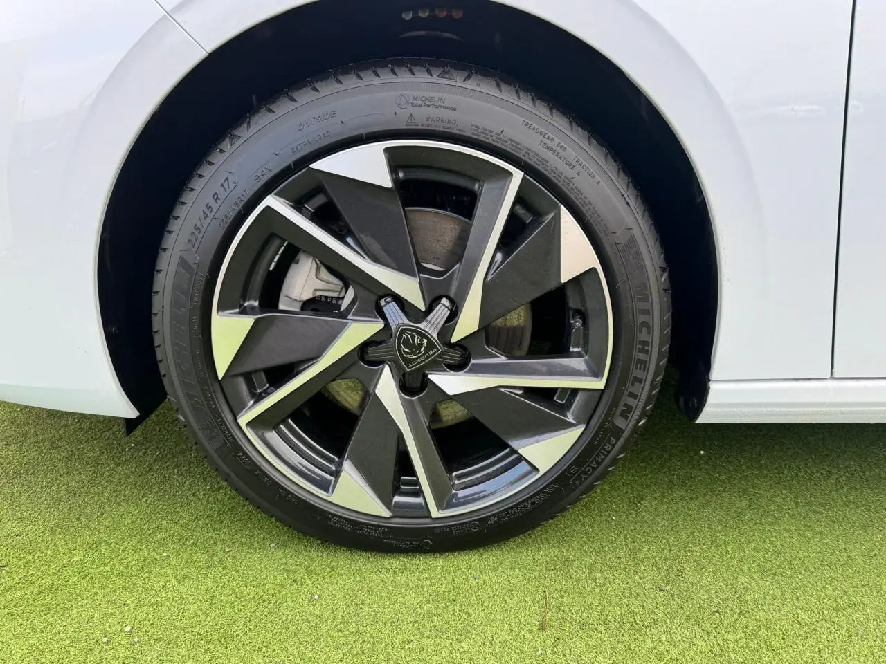 Gros plan sur la jante alliage 17'' Halong diamantée noire et argentée du côté gauche d'une Peugeot 308 SW blanc Okenite.