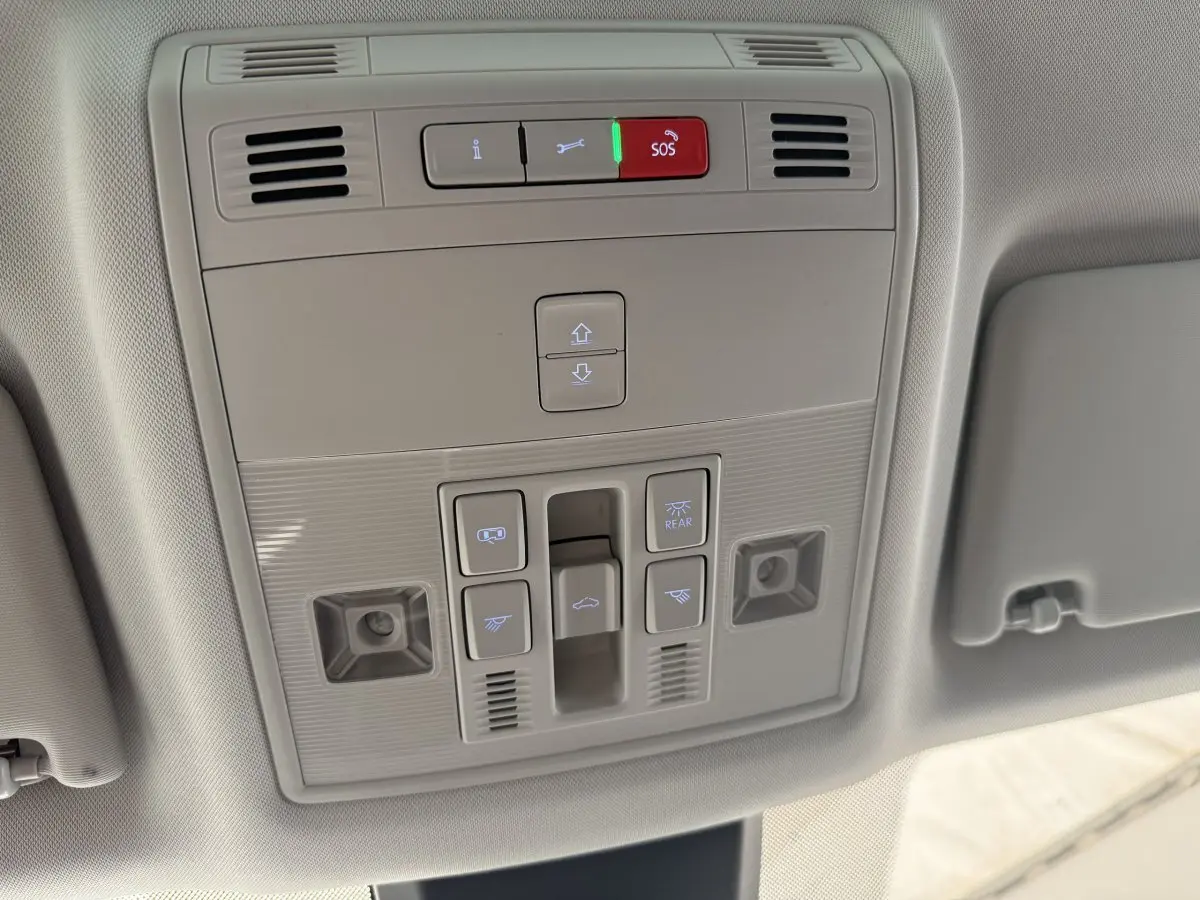 Vue en gros plan du panneau de commandes au plafond du SEAT Ateca gris clair 2023, avec boutons SOS et éclairage.