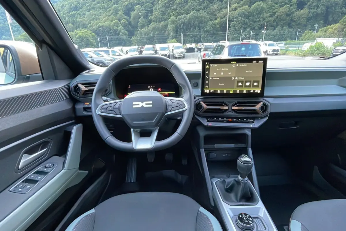Intérieur du Dacia Bigster TCE 130 4x4 Extreme Plus 2025, vue frontale sur le volant, tableau de bord et levier de vitesse manuel.