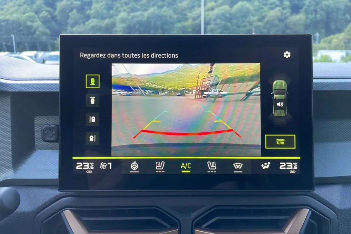 Écran central affichant la caméra de recul du Dacia Bigster vert cèdre, vue intérieure sur tableau de bord moderne.