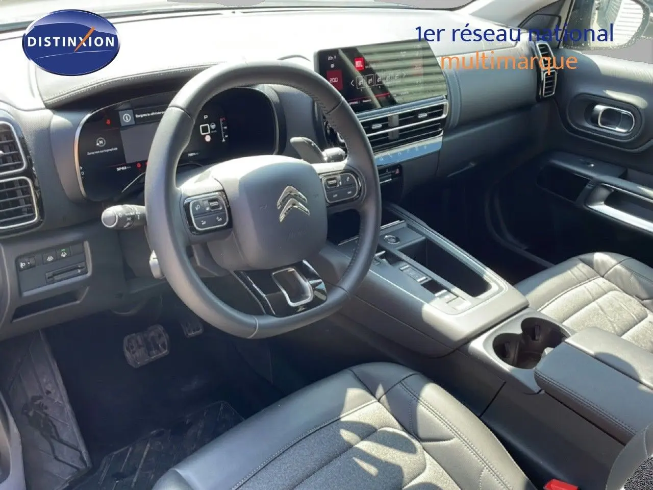 Vue intérieure côté conducteur du Citroën C5 Aircross gris platinium, avec tableau de bord numérique et sellerie cuir noire.