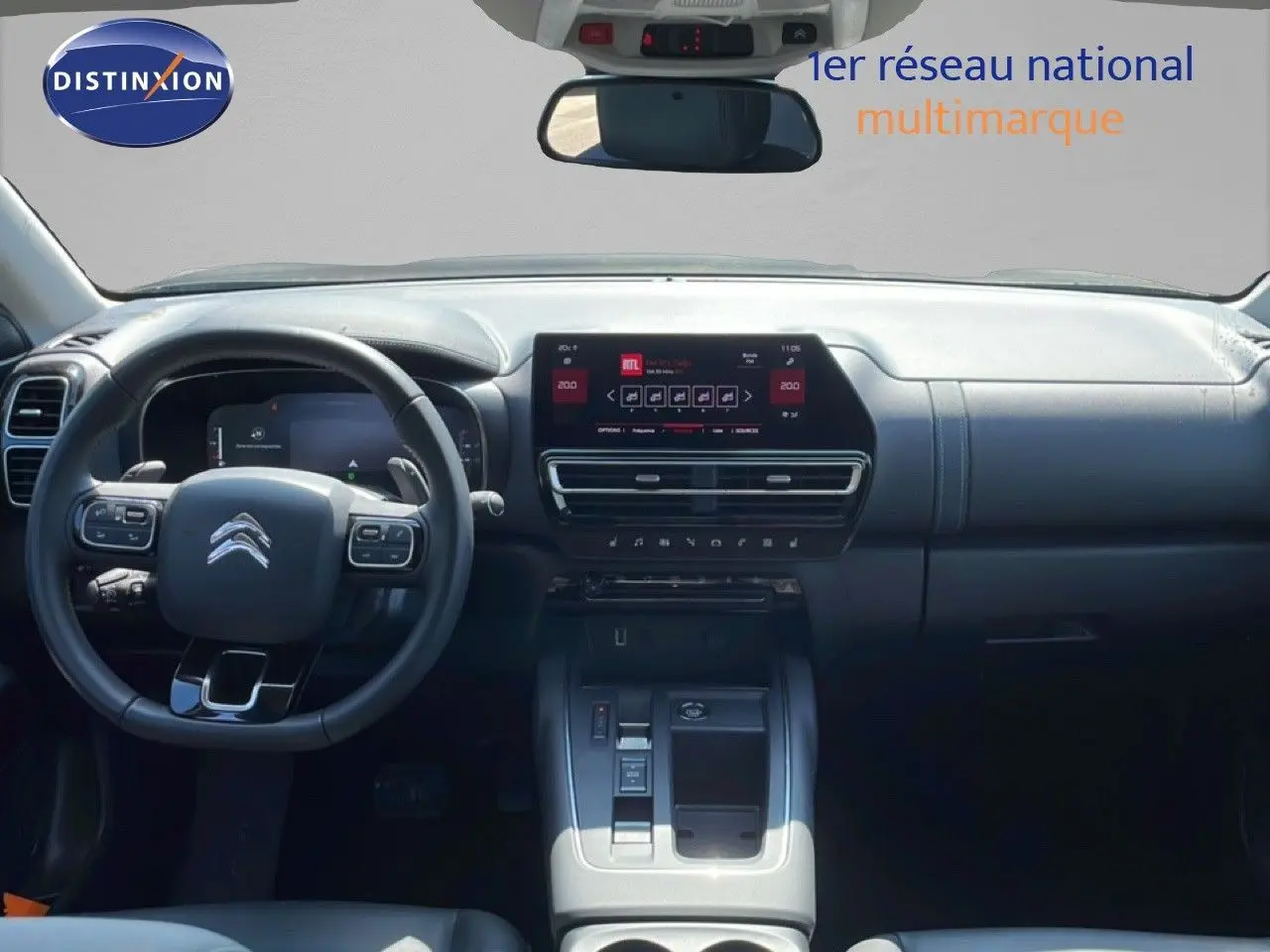 Vue intérieure avant du Citroën C5 Aircross gris platinium, tableau de bord moderne avec écran tactile central et volant multifonction.