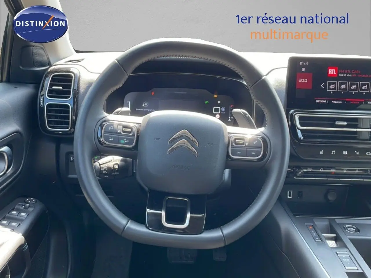 Vue intérieure centrée sur le volant noir du Citroën C5 Aircross 2025 avec tableau de bord digital et écran tactile.