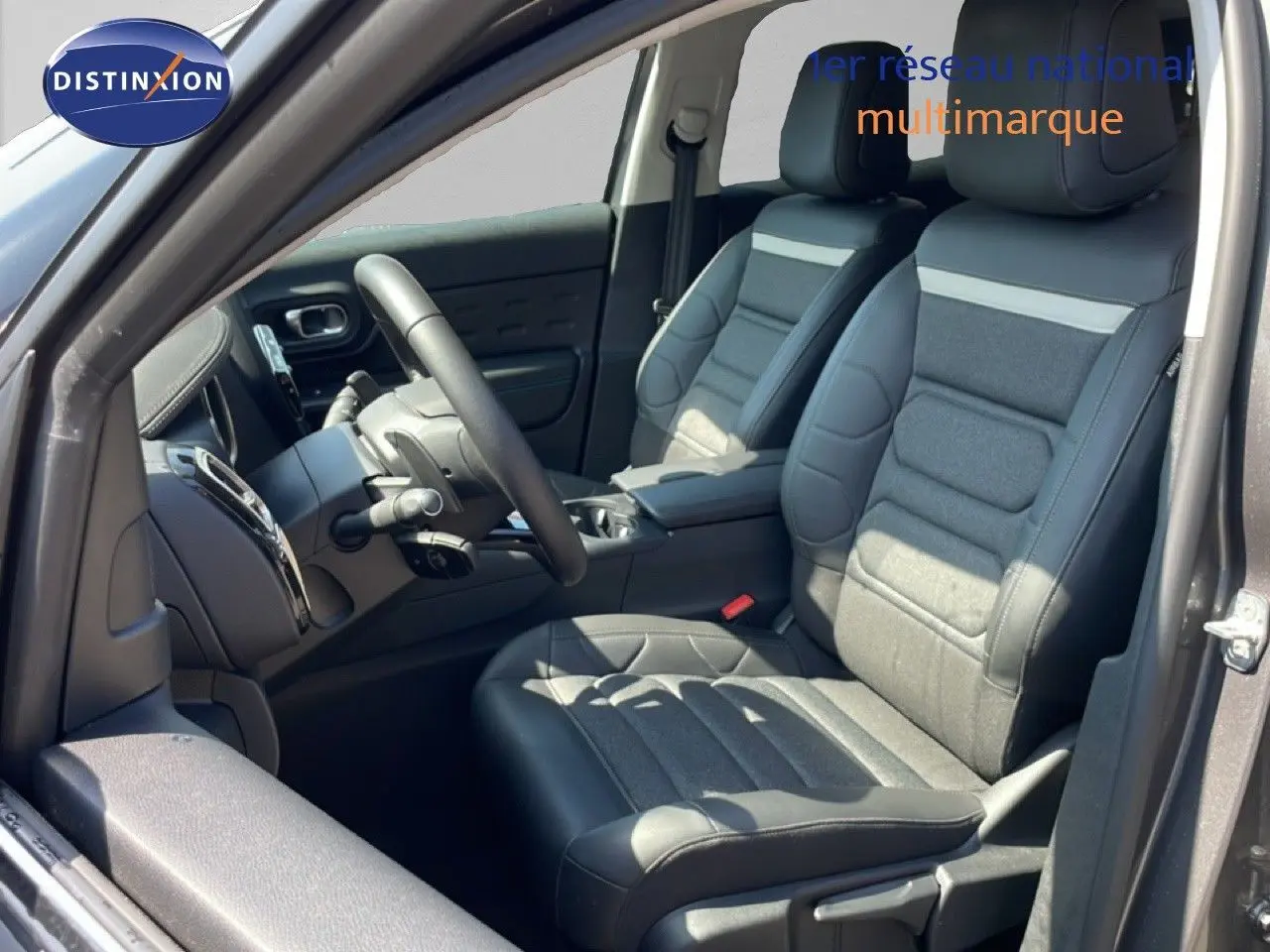 Vue intérieure côté conducteur du Citroën C5 Aircross gris platinium, sièges en cuir et tissu noir avec volant multifonction.