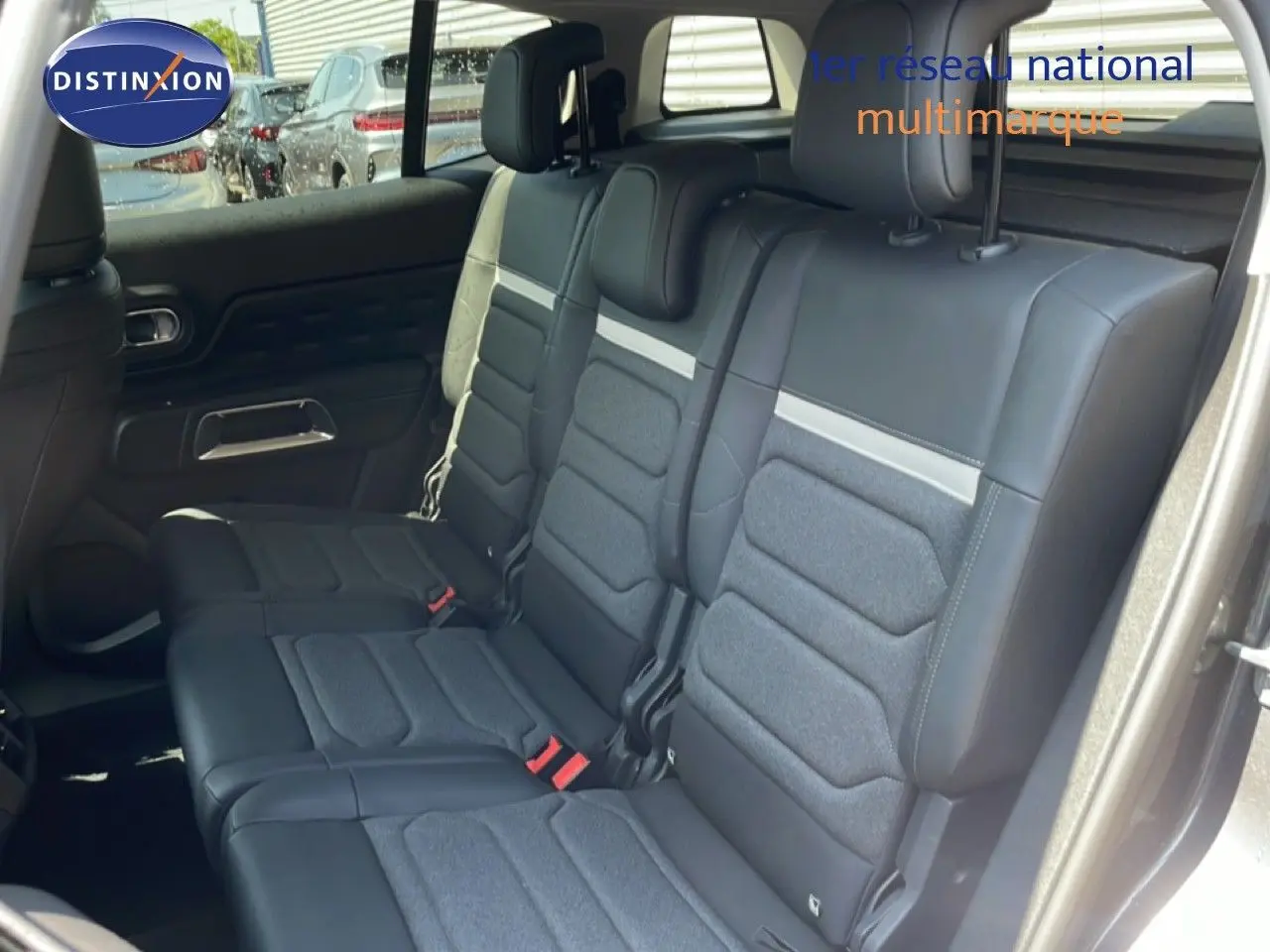 Vue intérieure montrant les sièges arrière en tissu et cuir noir du Citroën C5 Aircross gris platinium 2025, porte ouverte côté droit.