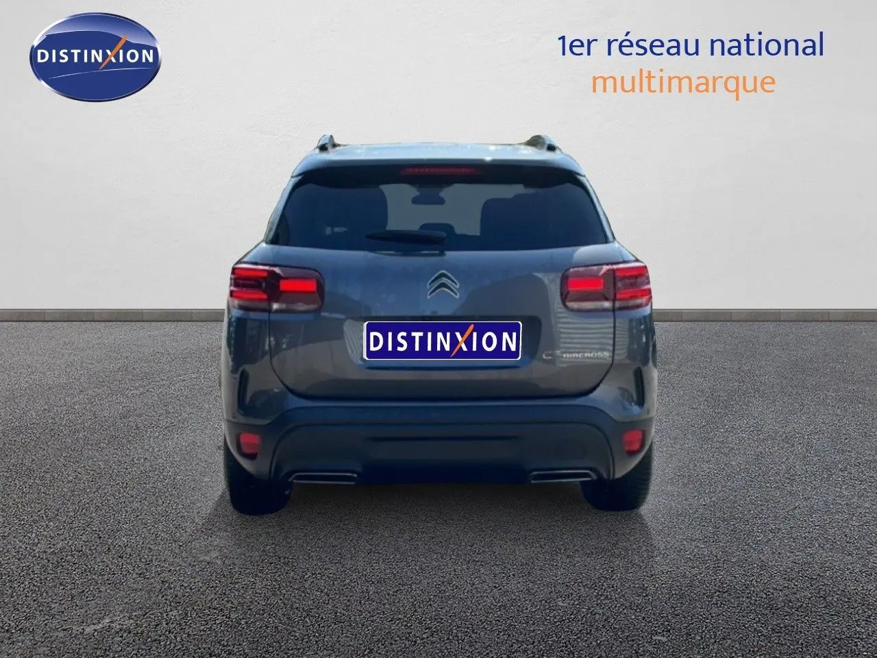 Vue arrière d'un Citroën C5 Aircross gris platinium métal, avec feux arrière allumés sur fond neutre.