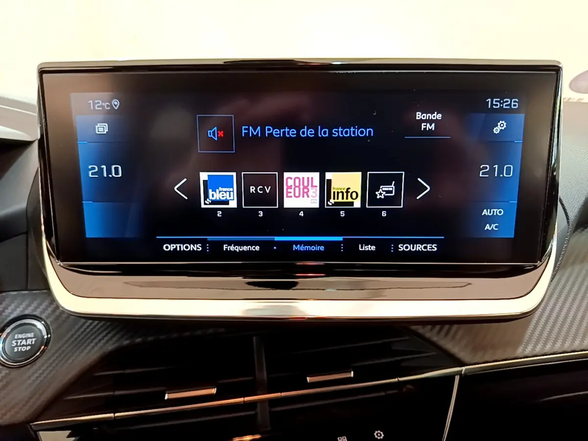 Écran tactile central de 7 pouces affichant la radio dans l'habitacle noir du Peugeot 208 Gris clair 2020.