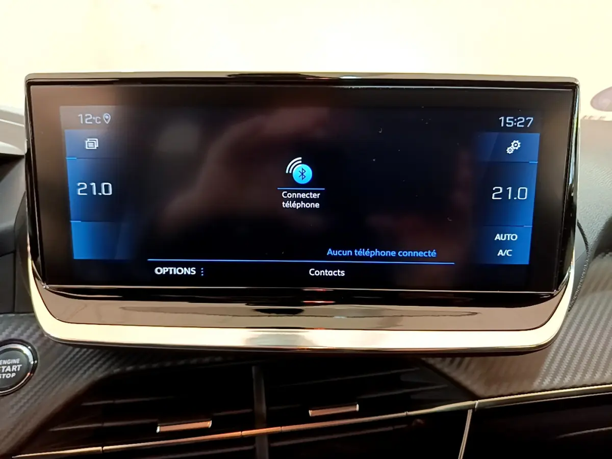 Écran tactile central affichant la connexion Bluetooth dans l'habitacle d'une Peugeot 208 gris clair, version Allure Business.