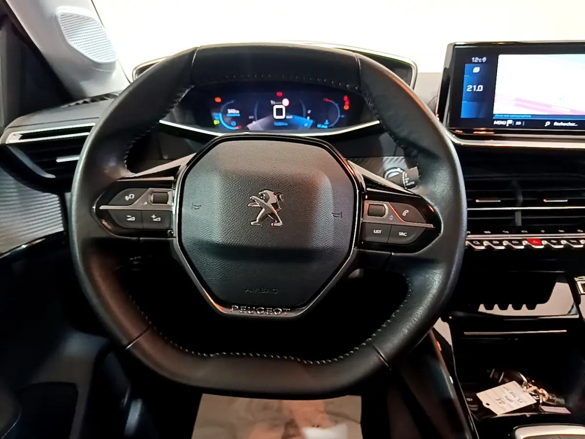 Vue rapprochée du volant cuir multifonctions et du tableau de bord numérique de la Peugeot 208 PureTech 100 S&S Allure Business.