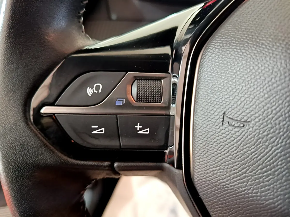 Gros plan sur les commandes du volant cuir noir de la Peugeot 208 PureTech 100 S&S Allure Business 2020.