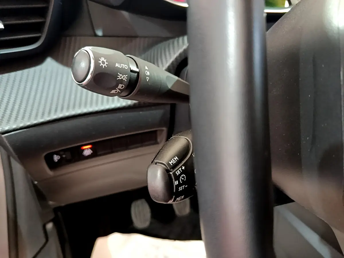 Gros plan sur les commandes au volant noir de la Peugeot 208 PureTech 100 S&S Allure Business 2020.