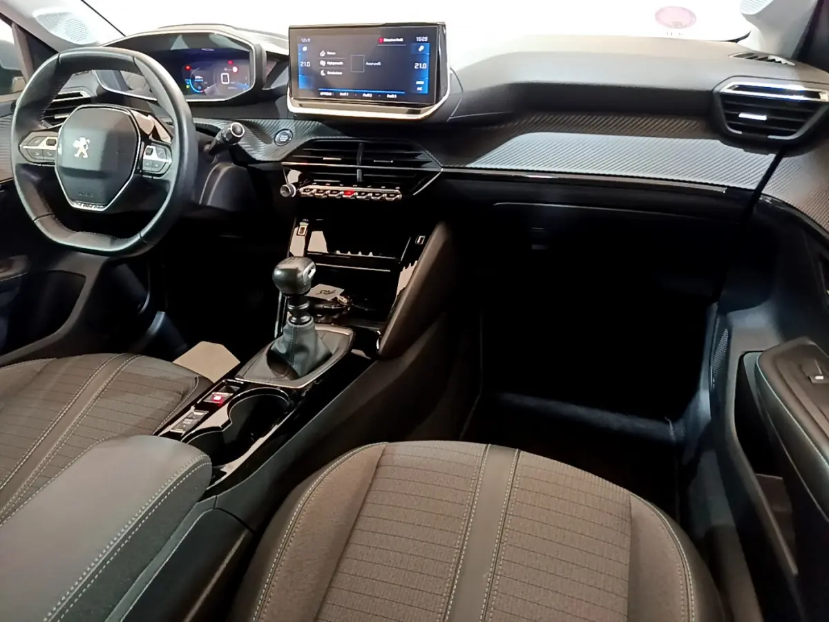 Intérieur de la Peugeot 208 PureTech 100 S&S Allure Business 2020, vue avant côté conducteur, tableau de bord moderne avec écran tactile.