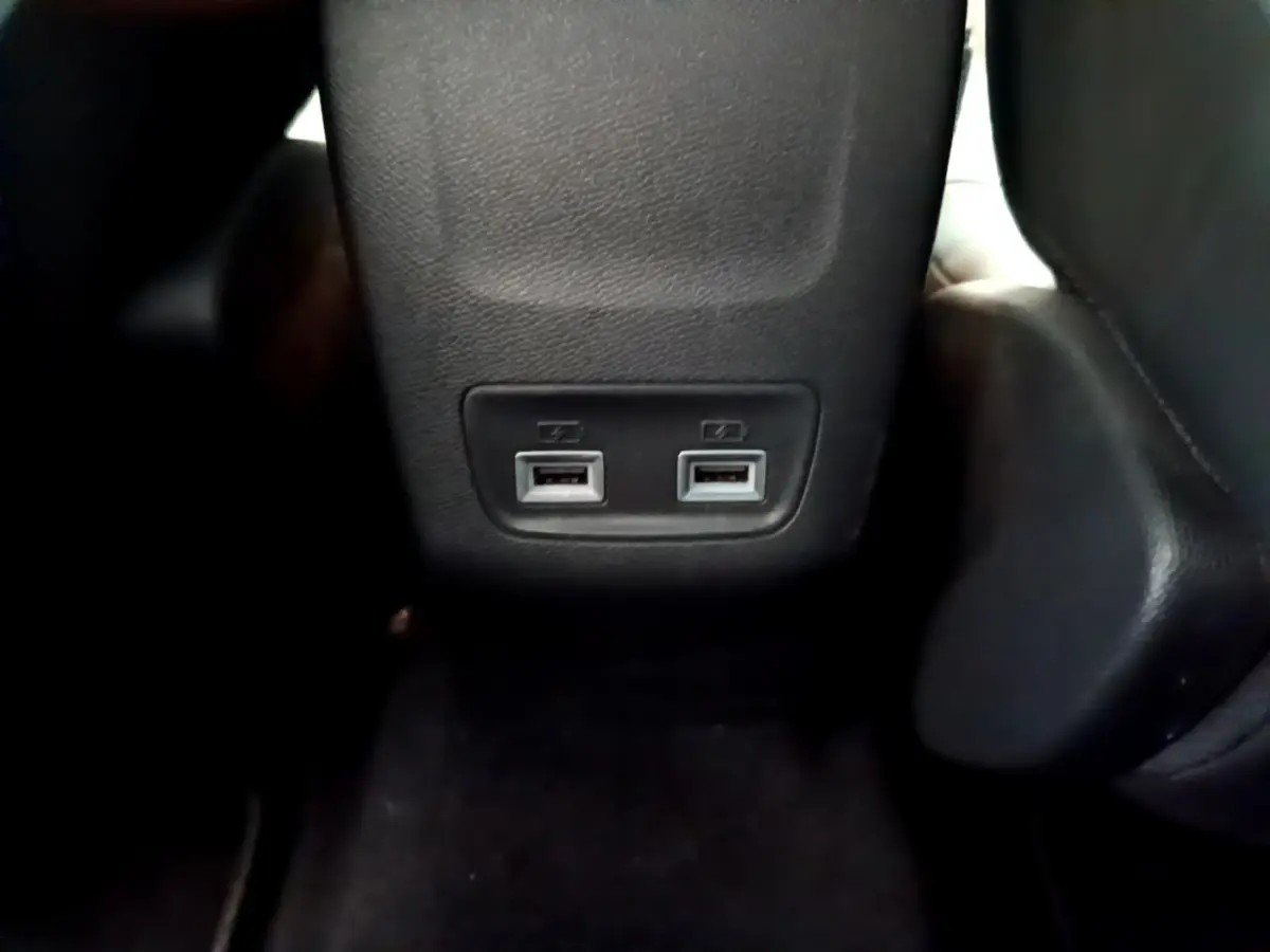 Vue rapprochée des deux ports USB situés à l'arrière de la console centrale d'une Peugeot 208 gris clair.