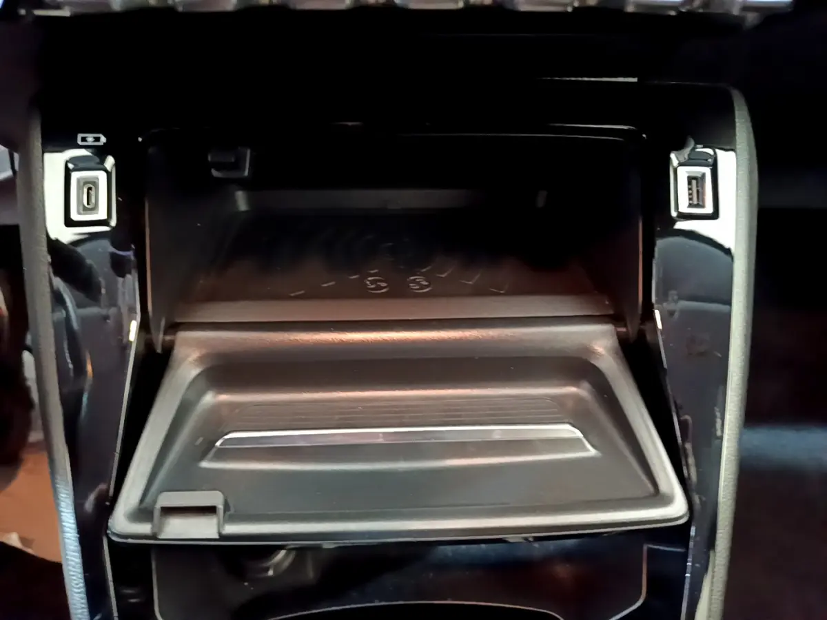 Vue rapprochée de la zone de rangement centrale avec recharge sans fil et ports USB sur Peugeot 208 gris clair 2020