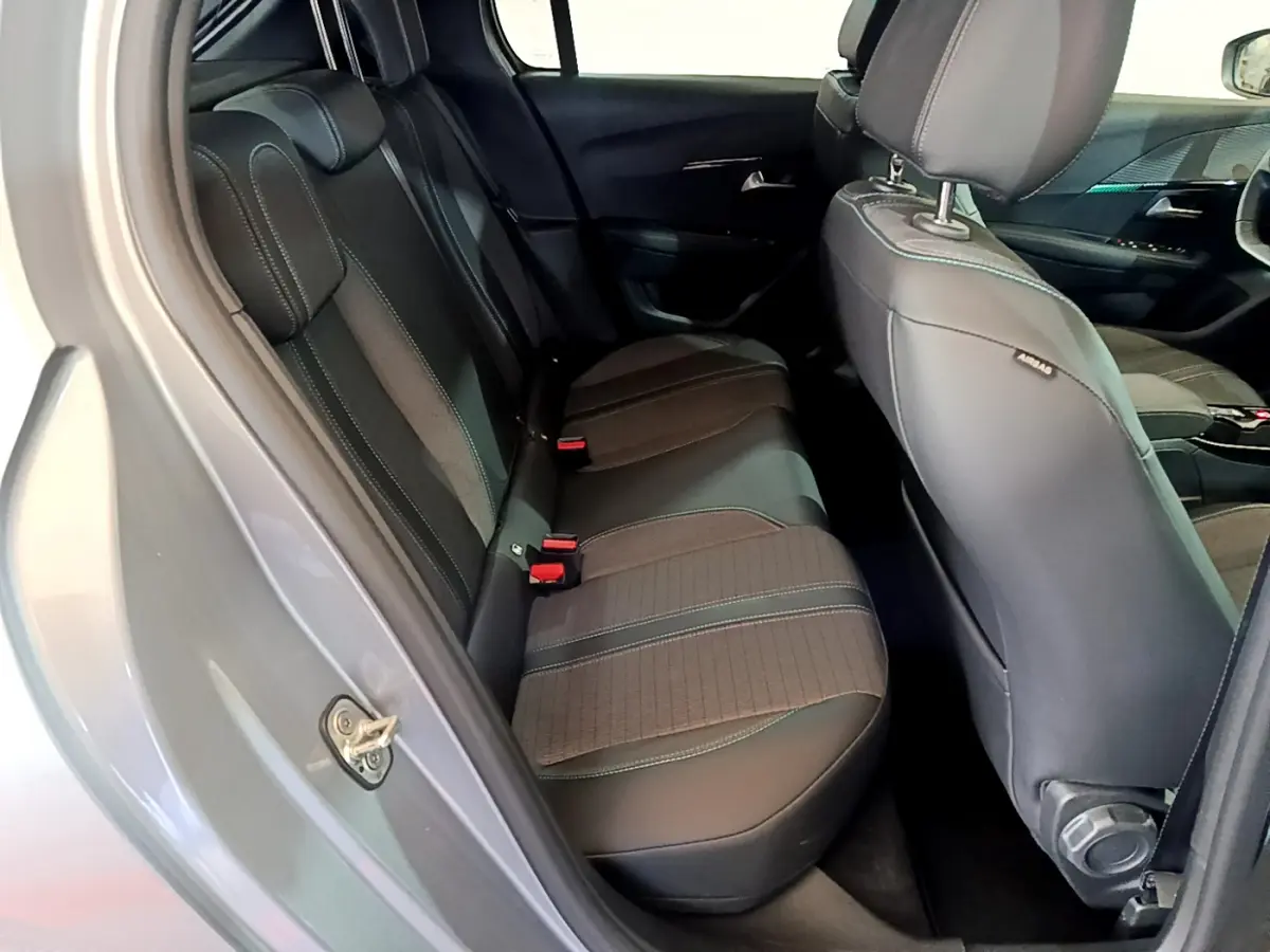 Vue intérieure côté gauche montrant la banquette arrière en tissu et cuir noir de la Peugeot 208 gris clair 2020.