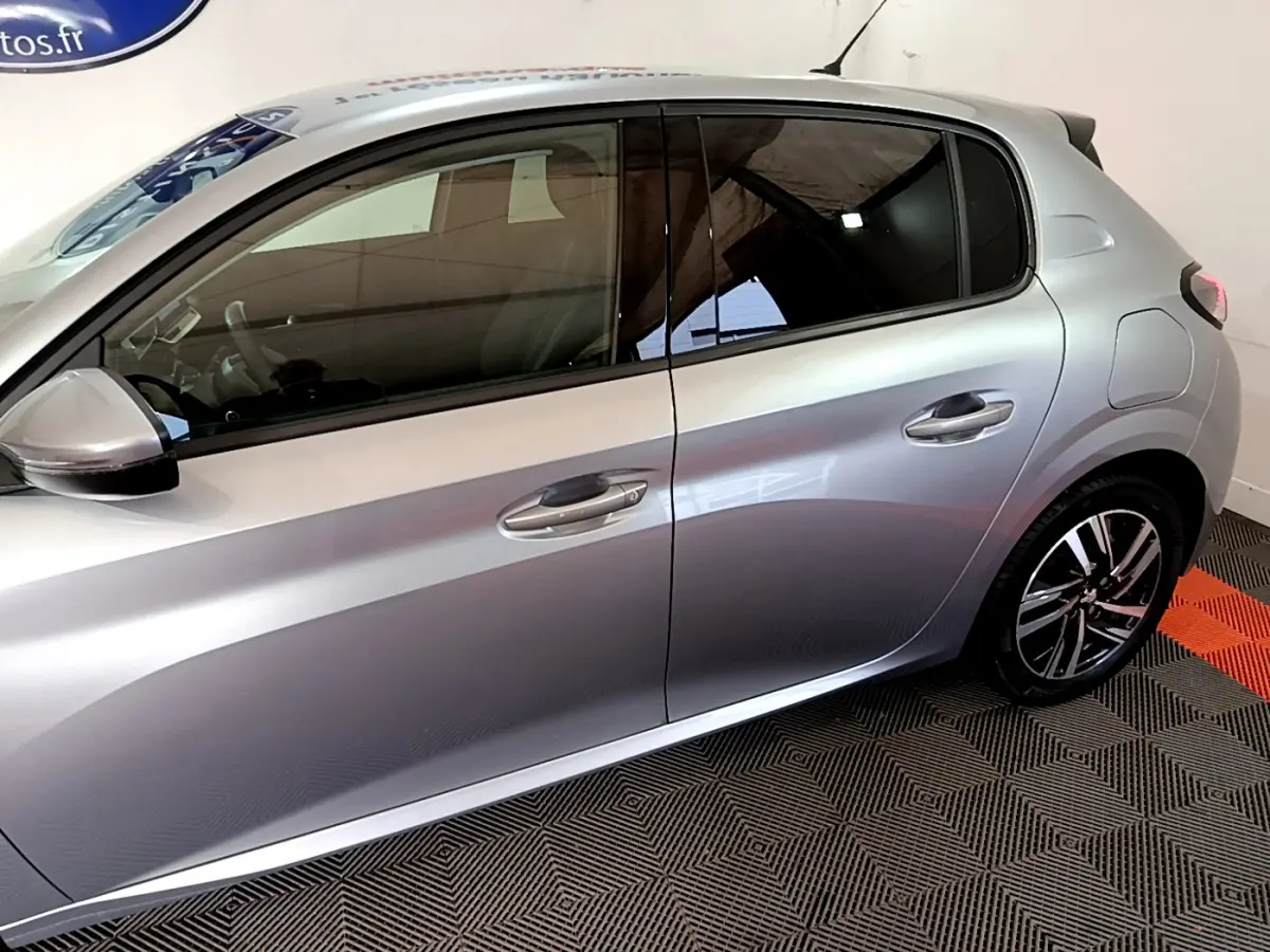 Profil côté gauche d'une Peugeot 208 gris clair 2020 avec jantes alliage et vitres teintées.