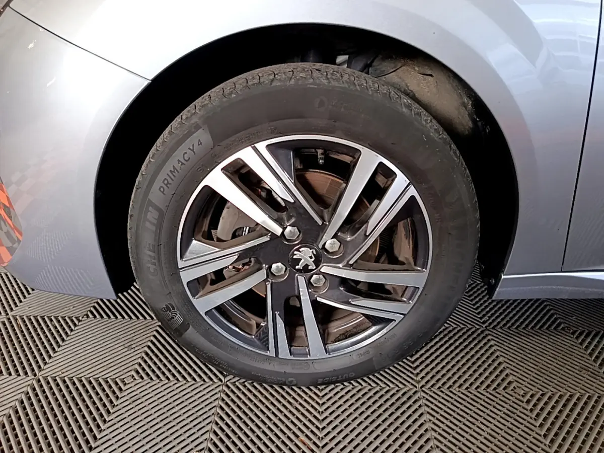Gros plan sur la roue avant gauche gris clair d'une Peugeot 208 PureTech 100 S&S Allure Business 2020.