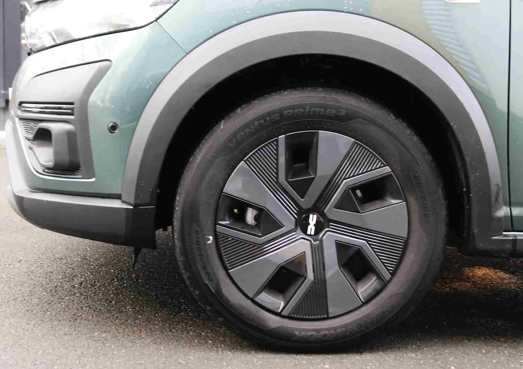 Gros plan sur la roue avant gauche du Dacia Jogger 2025 vert cèdre métal avec jante au design moderne noir et gris.