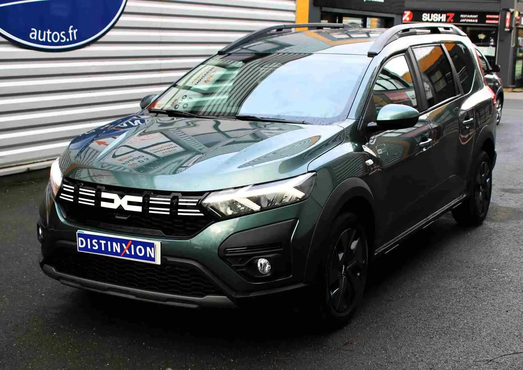 Dacia Jogger 2025 vert cèdre métal en 3/4 avant droit, avec calandre noire et jantes noires distinctives.