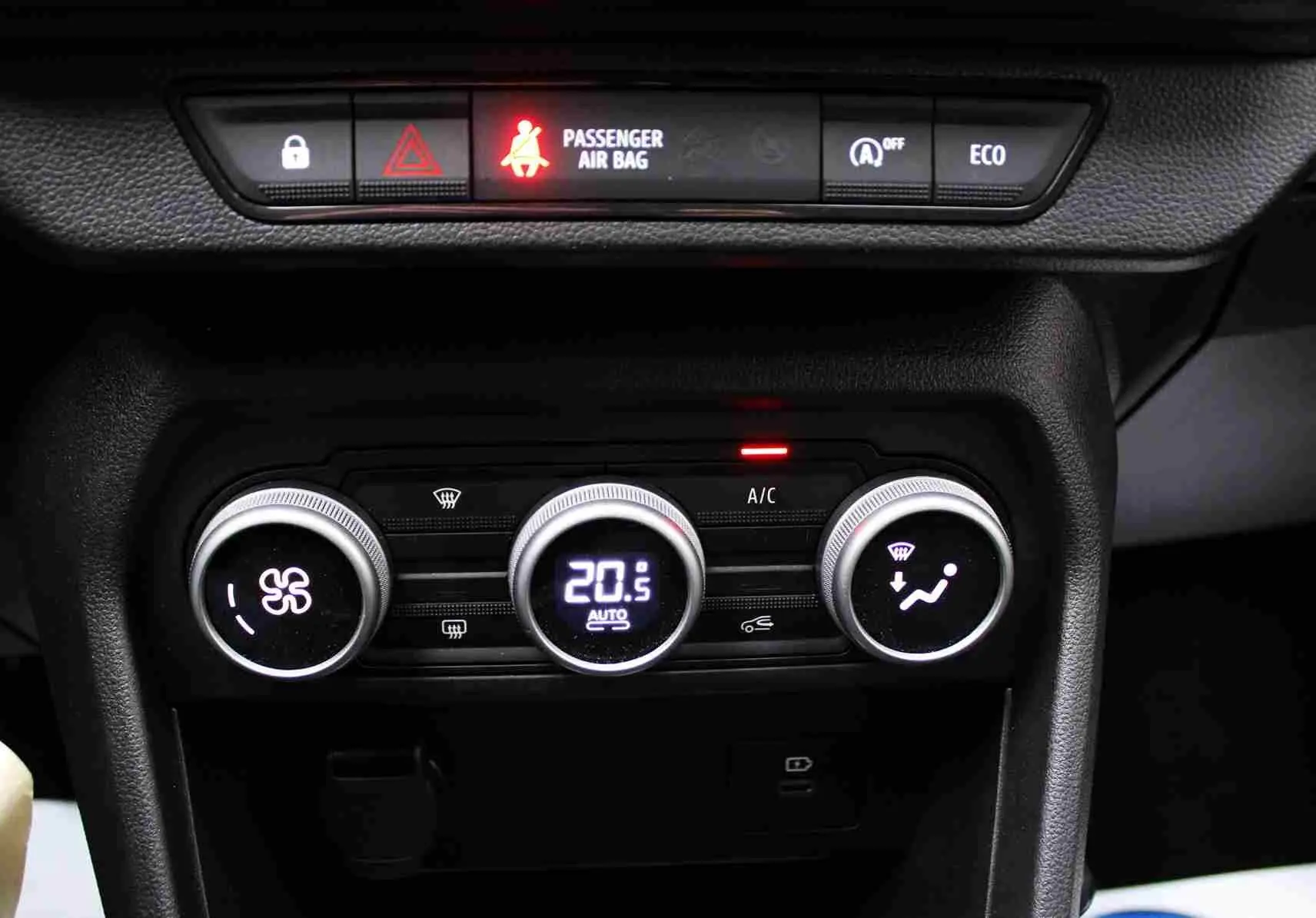 Gros plan sur la console centrale du Dacia Jogger 2025, montrant les commandes de climatisation et les voyants lumineux.