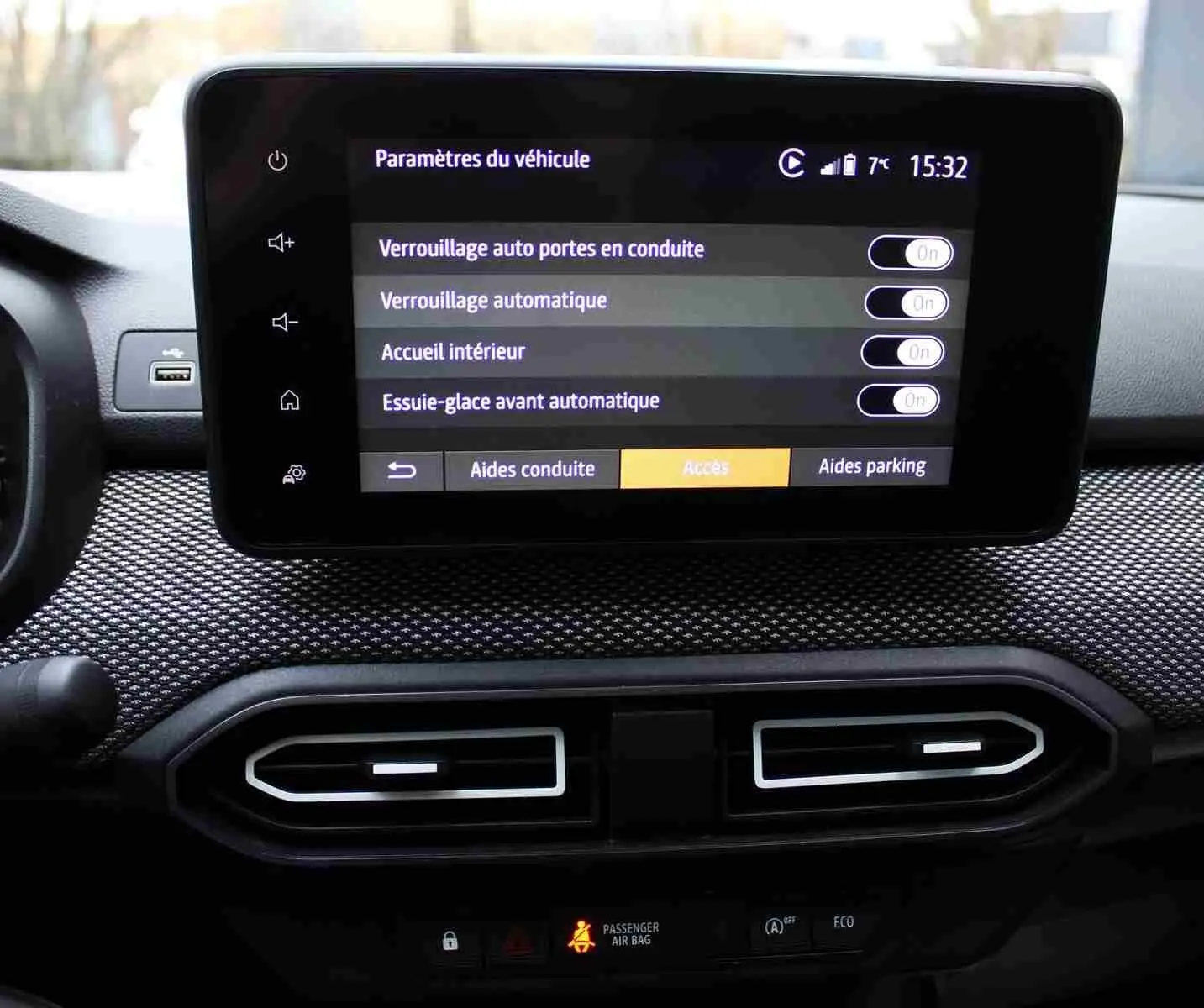 Écran central tactile du tableau de bord du Dacia Jogger 2025 affichant les paramètres de verrouillage et d’aide à la conduite.