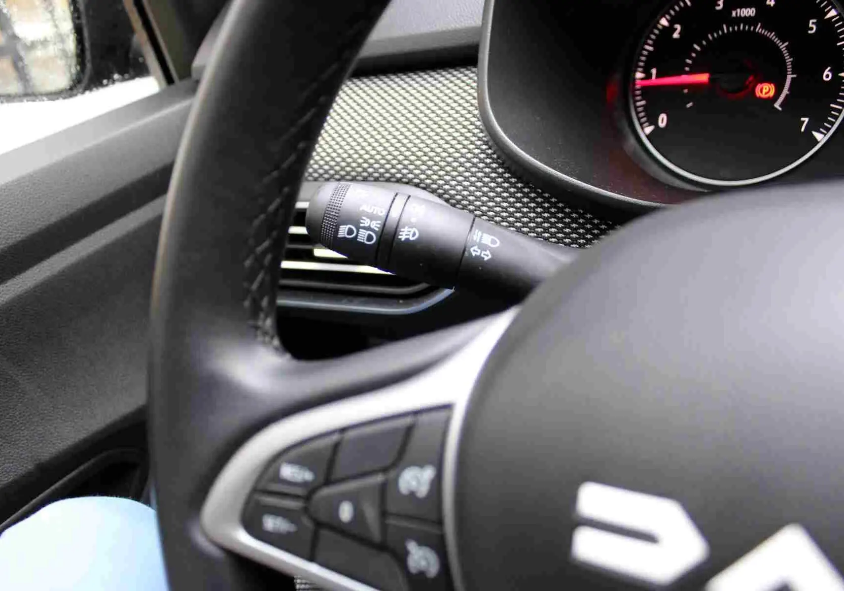 Gros plan sur le volant noir et la manette de clignotant du tableau de bord du Dacia Jogger 2025.