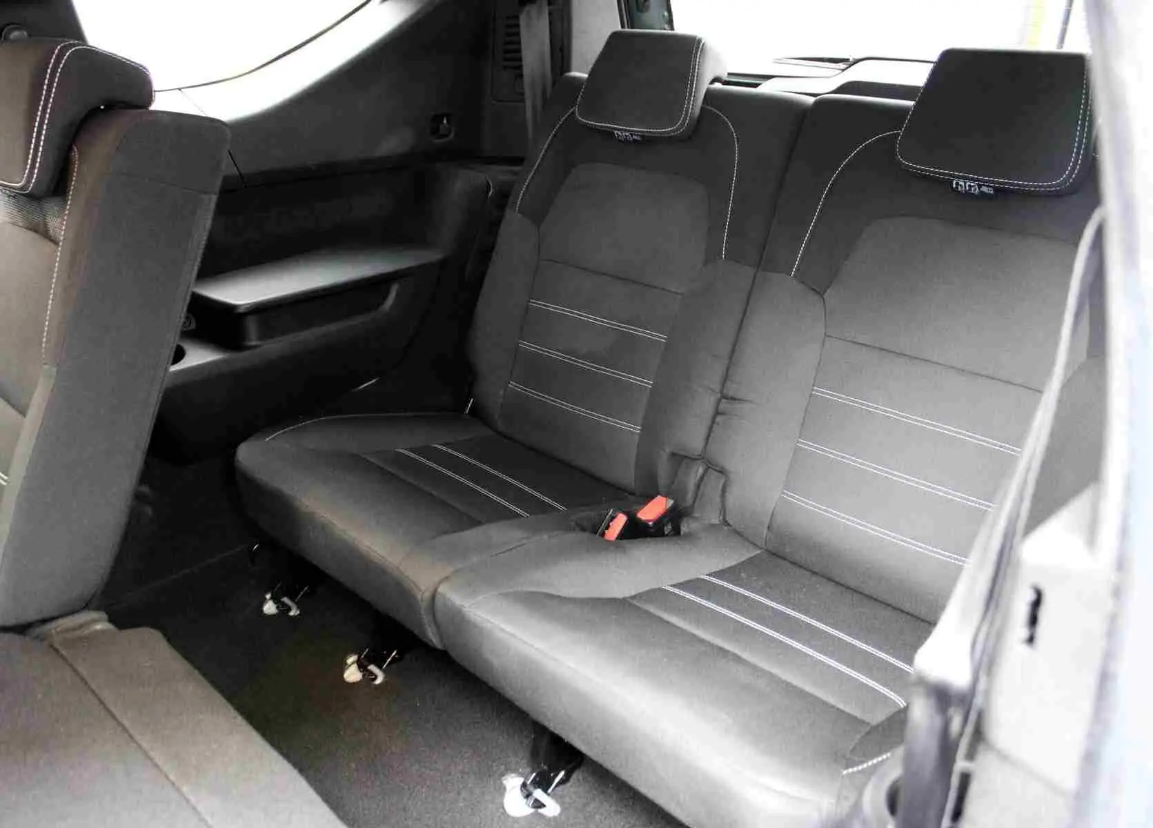 Vue intérieure sur la banquette arrière en tissu noir avec surpiqûres blanches du Dacia Jogger 2025.