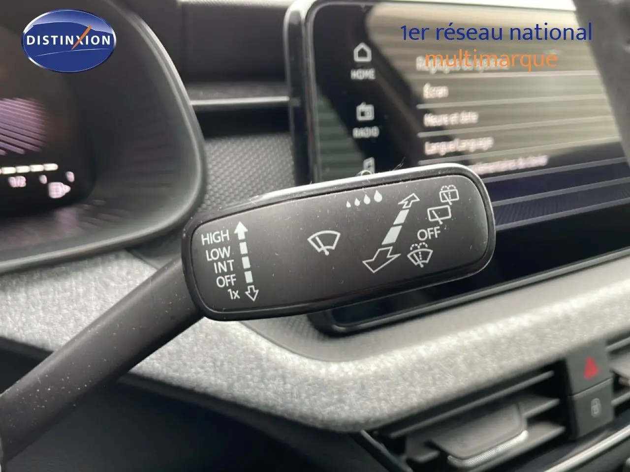 Gros plan sur la commande d’essuie-glace du Skoda Kamiq 2025, intérieur gris graphite avec écran tactile en arrière-plan.