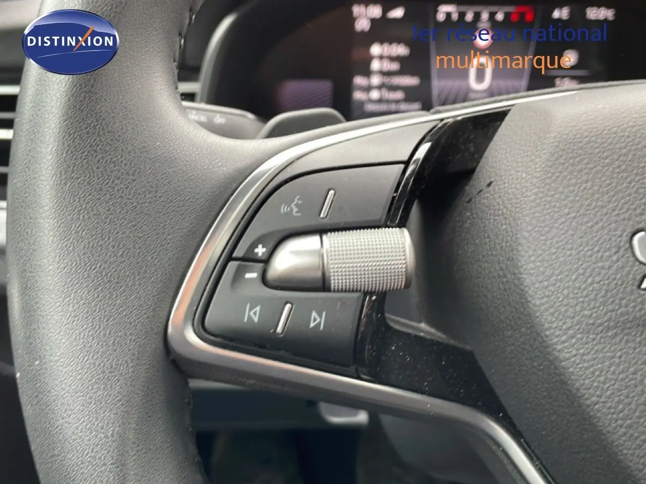 Gros plan sur la commande multimédia au volant du Skoda Kamiq 2025 gris graphite métal, avec molette texturée et boutons intégrés.