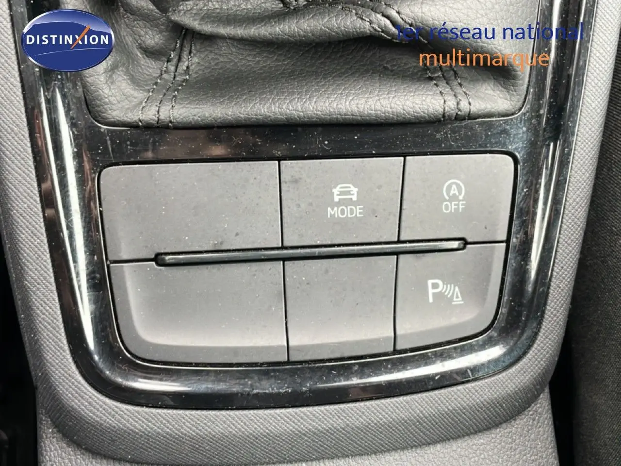 Gros plan sur les boutons de commande du mode de conduite et assistance au stationnement du Skoda Kamiq gris graphite.