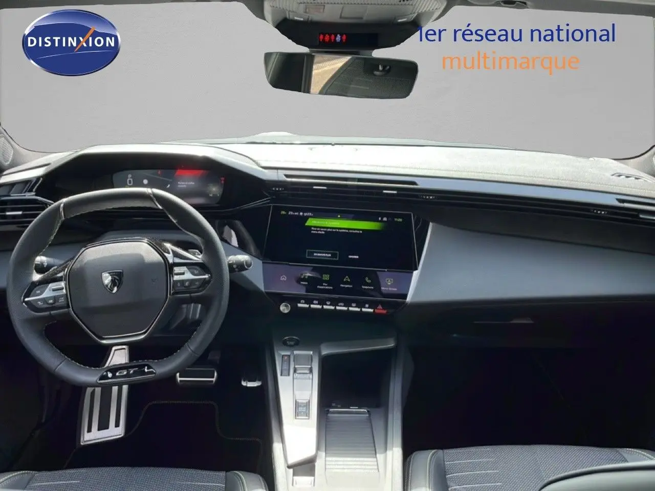 Vue intérieure avant de la Peugeot 308 gris Artense, volant GT, écran tactile et console centrale moderne.