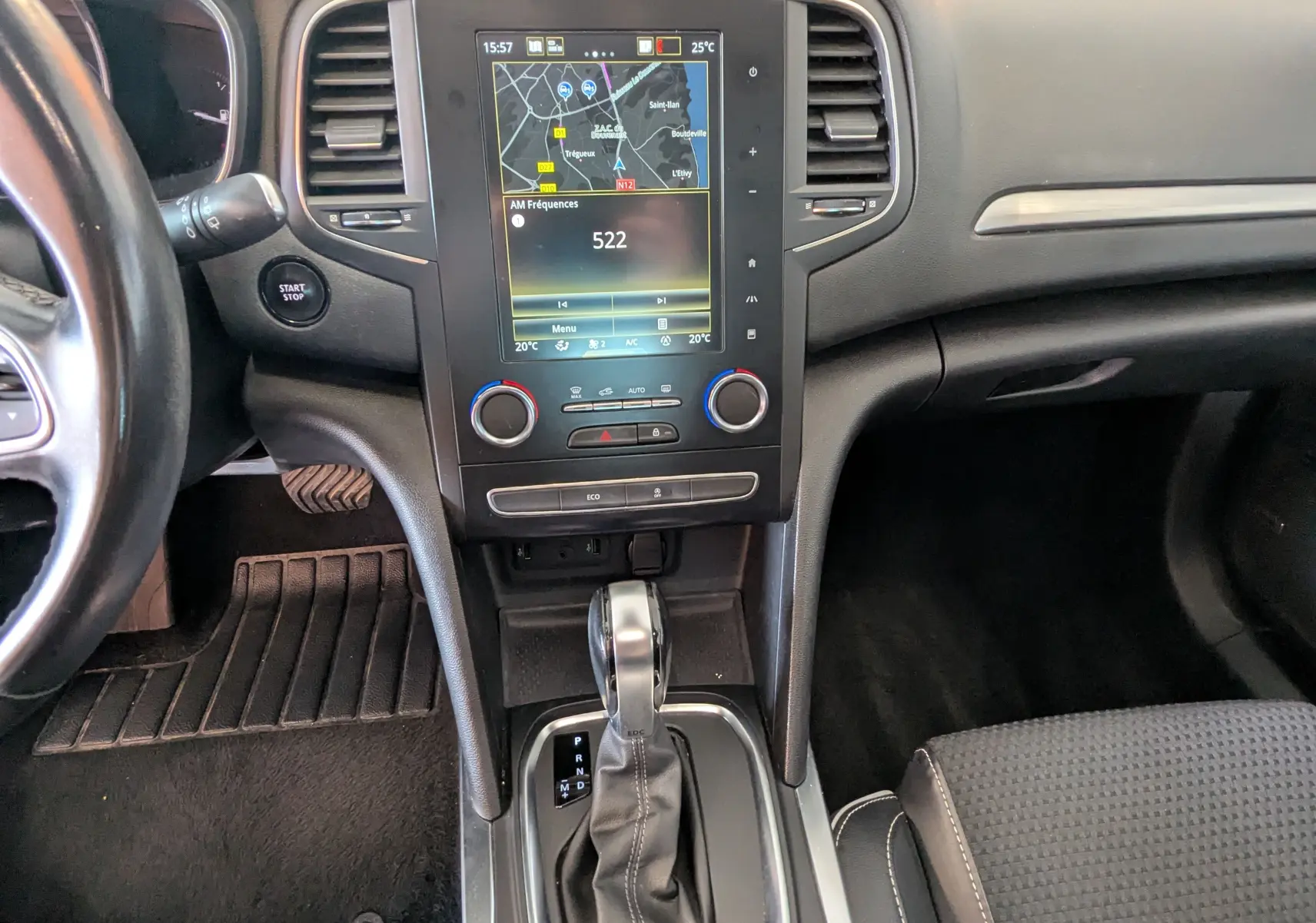 Vue intérieure centrée sur la console centrale d'une Renault Mégane IV grise avec écran tactile et levier de boîte automatique.