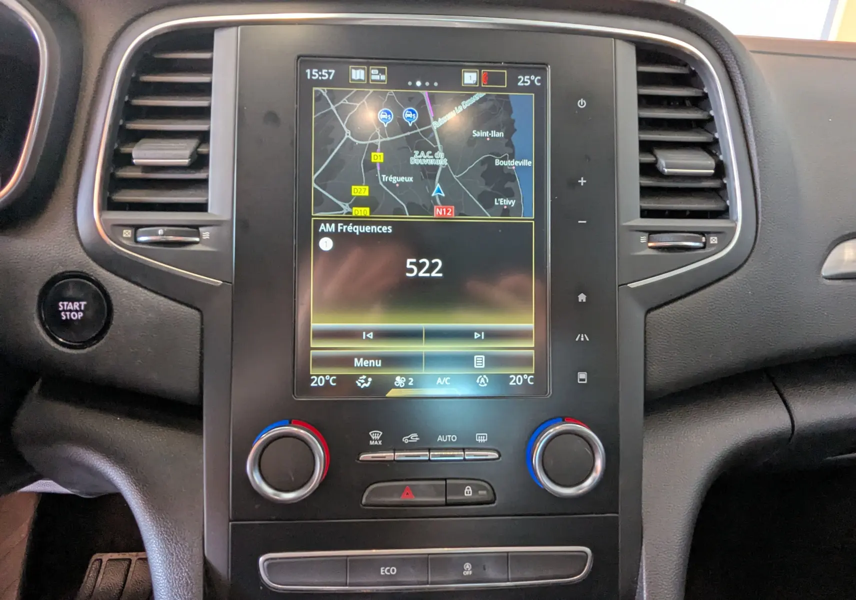 Vue rapprochée du tableau de bord de la Renault Mégane IV gris, avec écran tactile affichant la navigation et la radio.