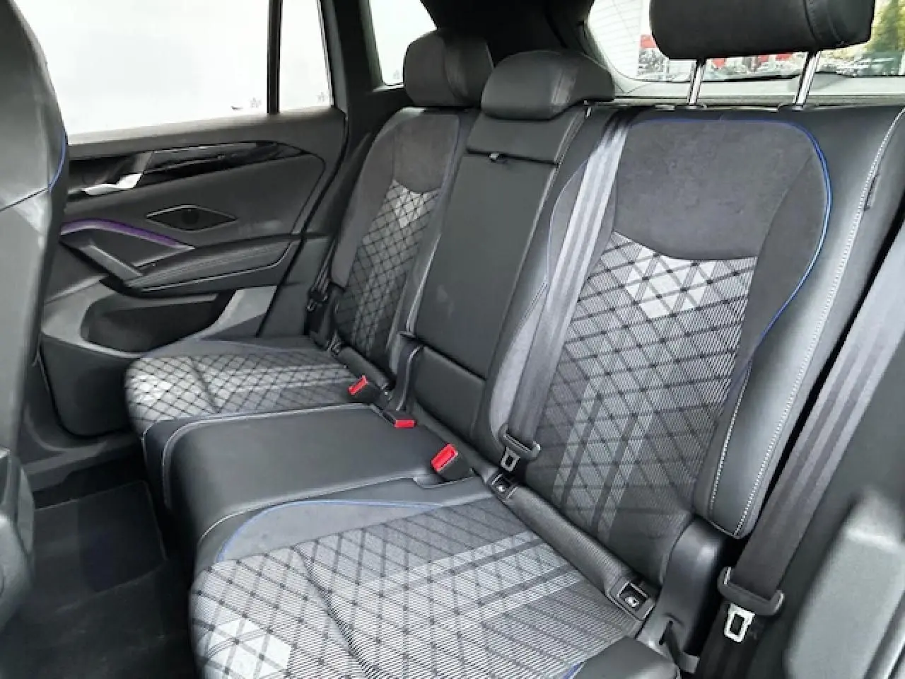 Banquette arrière en tissu ArtVelours gris avec surpiqûres bleues dans un Volkswagen Tiguan R-Line 2024, vue côté gauche.