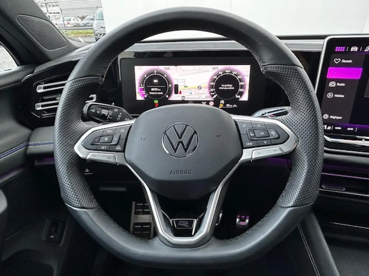 Volant cuir multifonction du Volkswagen Tiguan R-Line 2024 avec tableau de bord numérique et écran tactile visible.