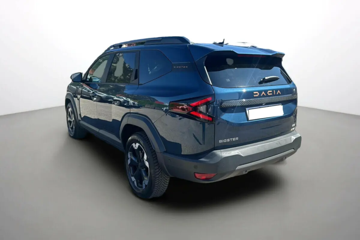 Vue 3/4 arrière droite du Dacia Bigster 2025 bleu indigo avec logo et feux arrière au design anguleux.