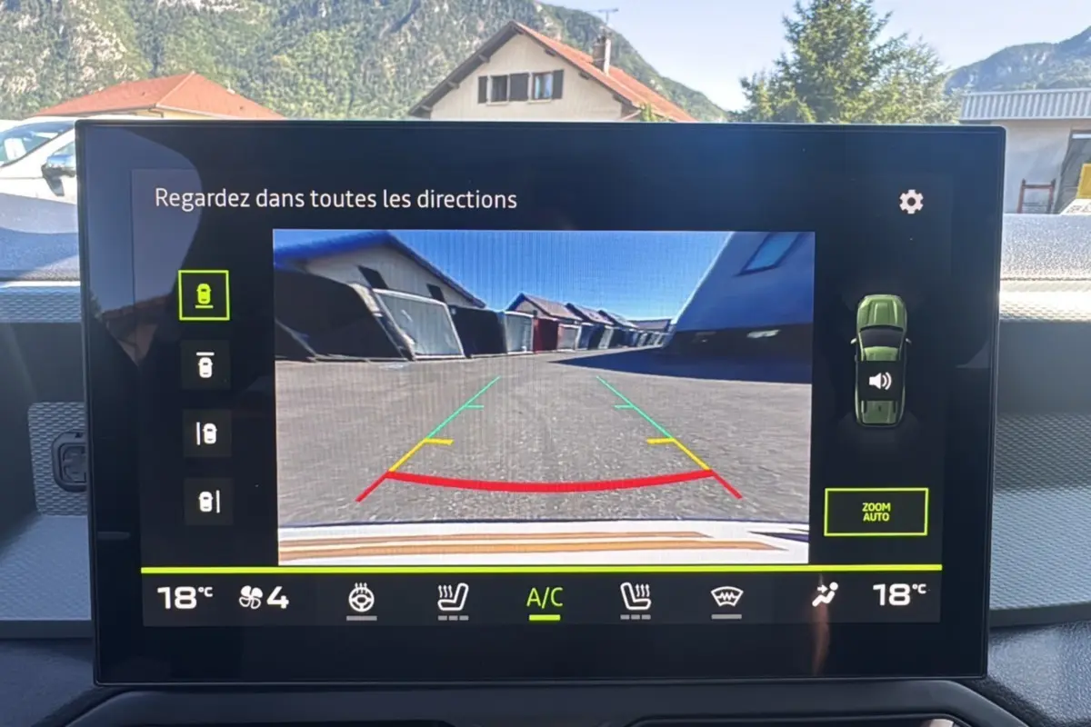 Vue de l'écran intérieur du Dacia Bigster bleu indigo 2025 montrant la caméra de recul avec guidage coloré.