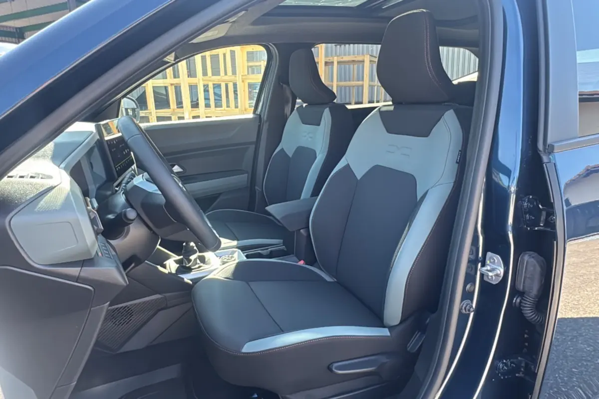 Intérieur du Dacia Bigster TCE 130 4x4 Extreme Plus 2025, vue côté conducteur, sièges bicolores noirs et gris.