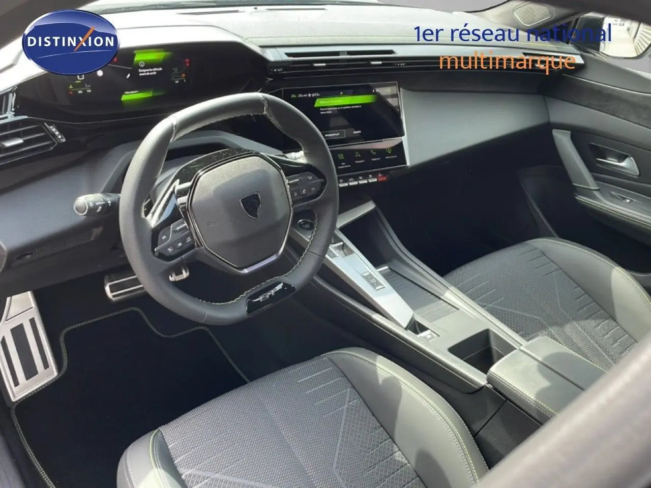Vue intérieure de la Peugeot 308 1.2 Hybrid 145ch GT, montrant le volant compact et la console centrale moderne en gris artense.