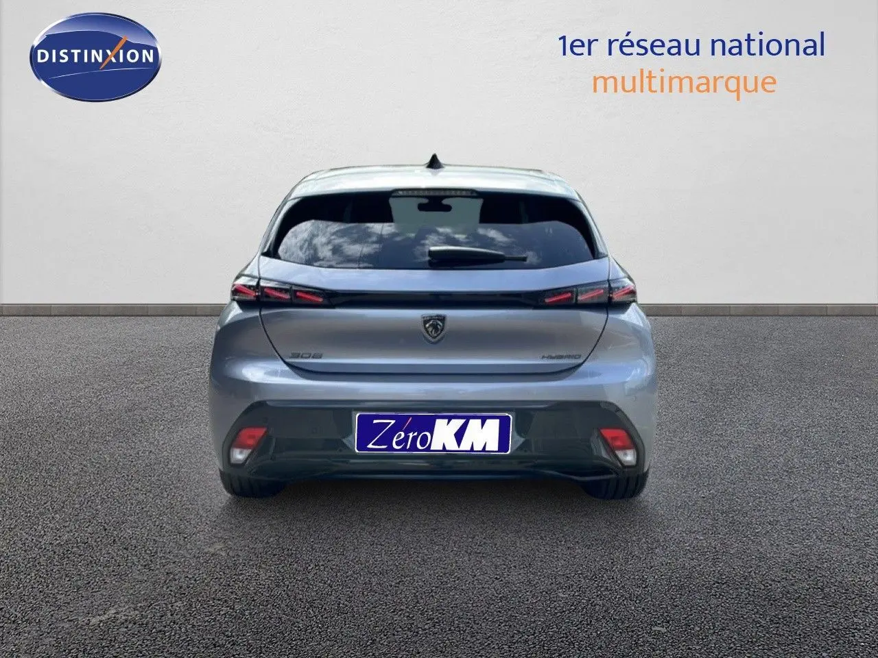 Vue arrière d'une Peugeot 308 gris Artense métal, version hybride 2026, avec feux arrière LED distinctifs.