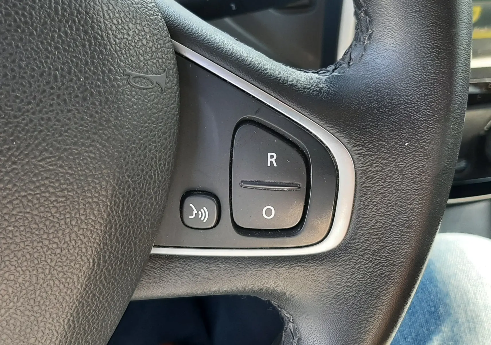 Gros plan sur les commandes de régulateur de vitesse au volant cuir noir du Renault Captur gris platine 2019.